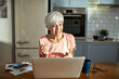 © Marko Geber - Excited senior woman video calling on laptop at home