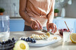 © Marko Geber - Happy senior woman cutting vegetables for smoothie in modern kitchen