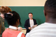 © Hernandez & Sorokina/Stocksy - Smiling teacher talking to his students