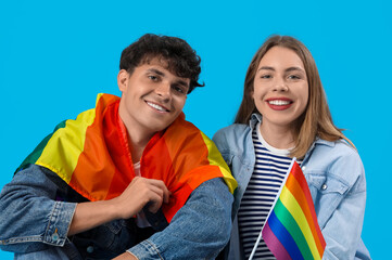 Wall Mural - Young couple with LGBT flags on blue background