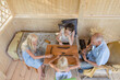 © Evgenij Yulkin/Stocksy - Grandmother and grandfather play dominoes with their granddaughters