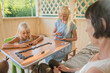 © Evgenij Yulkin/Stocksy - Children play domino game with grandmother