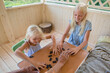 © Evgenij Yulkin/Stocksy - Children are shuffling the dominoes for a new game