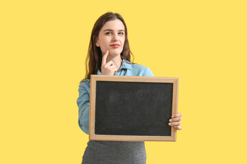 Poster - Thoughtful female teacher with chalkboard on yellow background