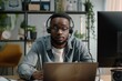 © Anjali - African man uses headset for remote communication and e learning.