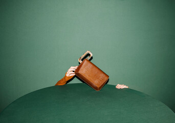 Abstract Image of Hands Holding a VIntage Brown Suitcase