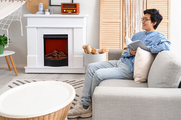 Sticker - Young Asian man reading book on his day off at home