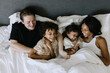 © Tanya Yatsenko/Stocksy - A portrait of a family in bed