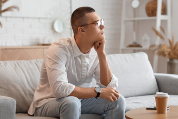 Wall Mural - Young man with wristwatch sitting at home