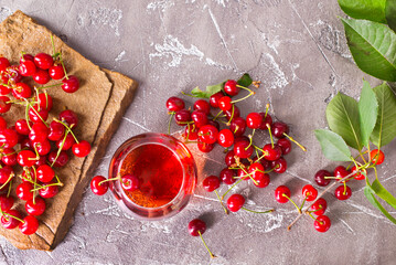 Wall Mural - Cherry juice in a transparent glass and fresh cherries