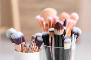 Wall Mural - Holders with makeup brushes at home, closeup