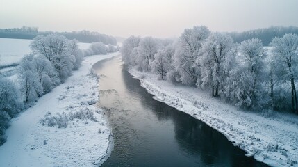 Sticker -   A snow-covered field surrounds a river, with snow-covered trees lining its banks