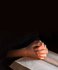 Canvas Print - Hands clasped in prayer near an open book