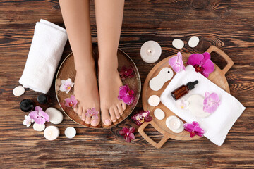 Wall Mural - Woman undergoing spa pedicure treatment on wooden background