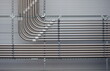 © rolfo/Stocksy - A series of pipes are hanging from the ceiling, with some