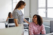 © BONNINSTUDIO/Stocksy - Two businesswomen sharing a laugh in busy open plan office