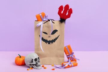 Sticker - Paper shopping bag with gifts and decorations for Halloween on color background