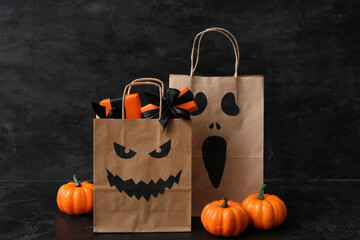 Poster - Paper shopping bags, gifts and pumpkins for Halloween on dark background