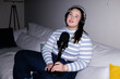 © Oleksii Syrotkin/Stocksy - Flash portrait of plus size podcaster creating audio content at home