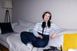 © Oleksii Syrotkin/Stocksy - Flash photo of plus size podcaster recording content sitting on sofa