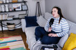 © Oleksii Syrotkin/Stocksy - Female content maker sitting cross-legged during podcast broadcasting