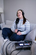 © Oleksii Syrotkin/Stocksy - Content maker sitting cross-legged on sofa during podcast broadcasting