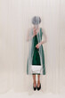 © Ulas&Merve/Stocksy - Mysterious Woman Behind Sheer Curtain Holding White Handbag