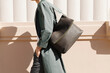 © Ulas&Merve/Stocksy - Elegant Woman Walking with Stylish Leather Bag in Urban Setting