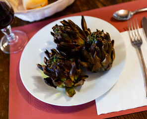 Sticker - Whole roasted artichokes on plate served as healthy vegetable dinner