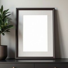 black picture frame hanging on a white wall above a black dresser