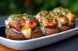 © Sanchai - Tapas bite of stuffed mushrooms with garlic and cheese, captured in a photo where mushrooms are stuffed with a garlic and cheese mixture, baked until golden, and served hot on a small dish