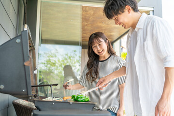 Canvas Print - バーベキュー・キャンプ・BBQ・焼き肉・グランピングをする男女（ホームパーティー・ベランピング））
