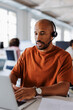 © BONNINSTUDIO/Stocksy - Focused male customer service representative working on laptop