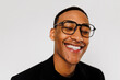 © BONNINSTUDIO/Stocksy - Man wearing glasses laughing on white background