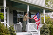 © Raymond Forbes LLC/Stocksy - Senior  Veteran display American Flag at House
