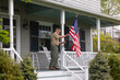 © Raymond Forbes LLC/Stocksy - Senior military  Veteran display American Flag at House