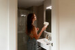 © Alba Vitta/Stocksy - Woman Drying Hair in Bathroom