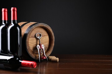 Canvas Print - Wing corkscrew, corks, bottles of wine and barrel on wooden table, space for text