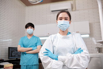 Portrait of two professional dental occupation workers partner in uniform, female dentist and male assistant, teeth healthcare, hygiene work in dental clinic hospital, happy smile, and look at camera.