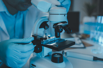 Wall Mural - a scientist uses a microscope to look for contaminants in a test sample, a researcher uses a microsc