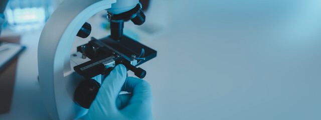 Wall Mural - a scientist uses a microscope to look for contaminants in a test sample, a researcher uses a microsc