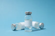 © Atlas - Glass medical bottles with vaccine on blue background, close up