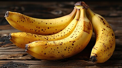 A group of ripe bananas with brown spots on a wooden background.