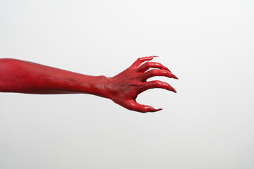 a witch's hand with long red nails on a white background, resembling a demon's or zombie's hand. thi