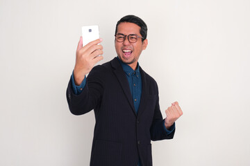 A businessman showing excited expression when looking at his mobile phone