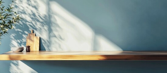 Poster - Wooden desk with empty space and a kitchen board featuring a blue wall and shadows