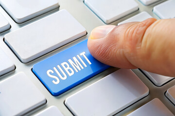 Finger pressing submit button on a white computer keyboard. online application, digital submission, form submission concept.