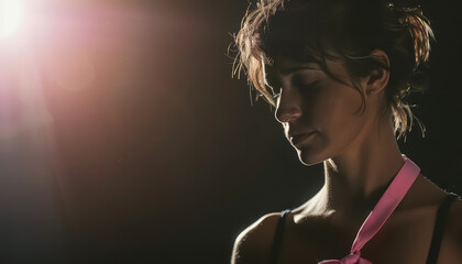 Wall Mural - A woman is sitting in a dark room with her head down