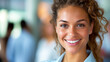 © Volodymyr - Smiling woman with curly hair in a bright office setting