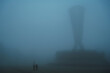 © alexkoral - backs of mother woman with child son walking in a misty foggy mystical park in evening. A misty landscape with people in autumn in a misty fog mist haze in Independence Park in Shymkent in Kazakhstan